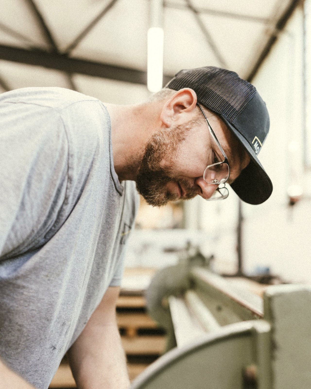 Dachdecker in der Werkstatt, konzentriert beim Materialzuschnitt