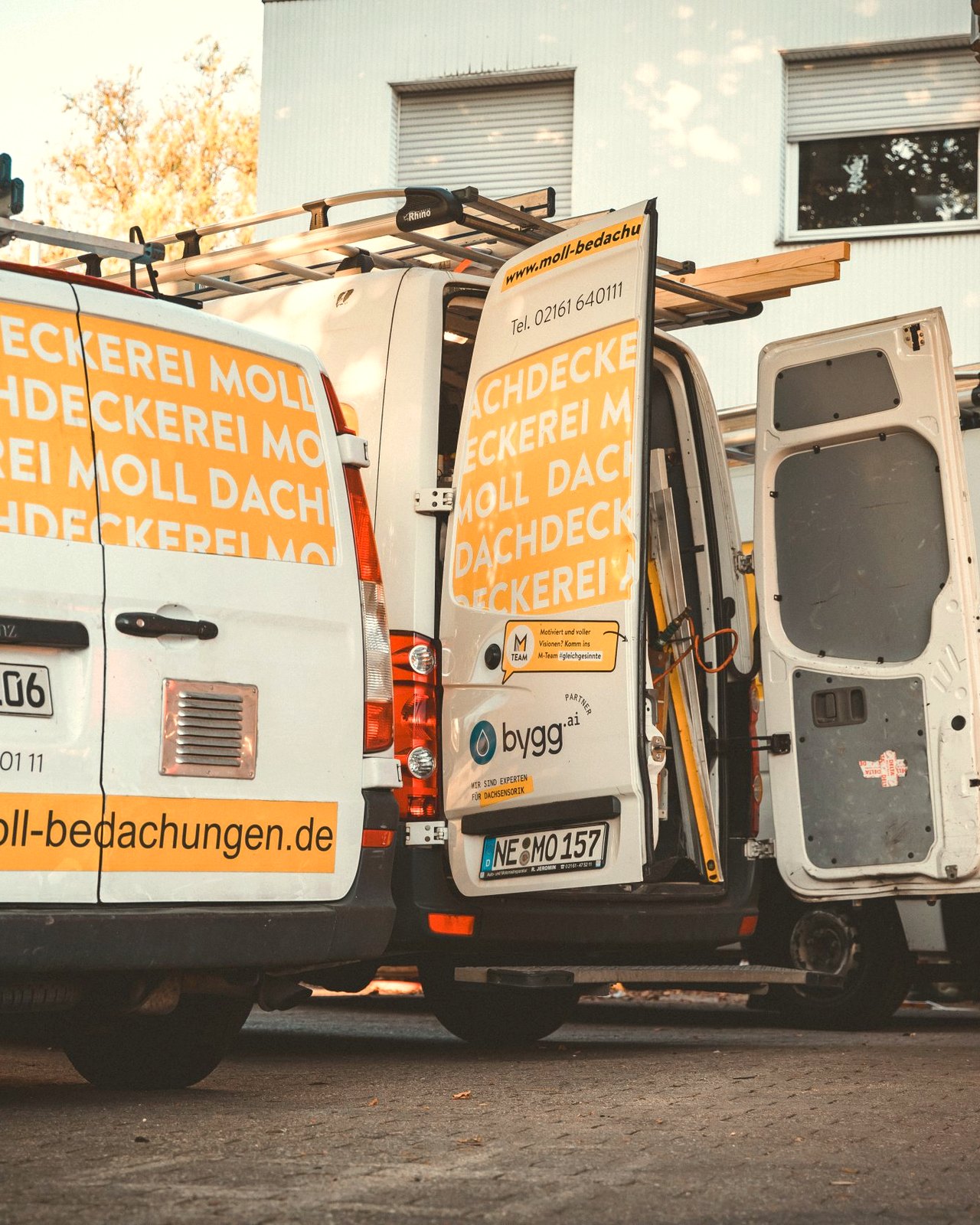Moll-Servicefahrzeug mit Dachdeckerei-Branding, geöffnete Türen und Materialaufbau