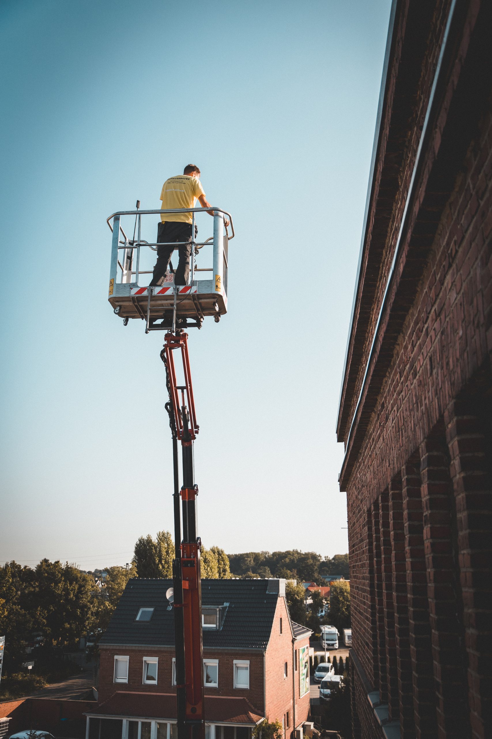 Dachdecker bei der Arbeit — Cherrypicker vor dramatischem Himmel