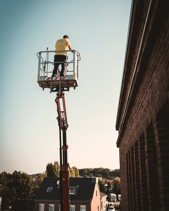 Dachdecker in der Arbeitsbühne am Steildach