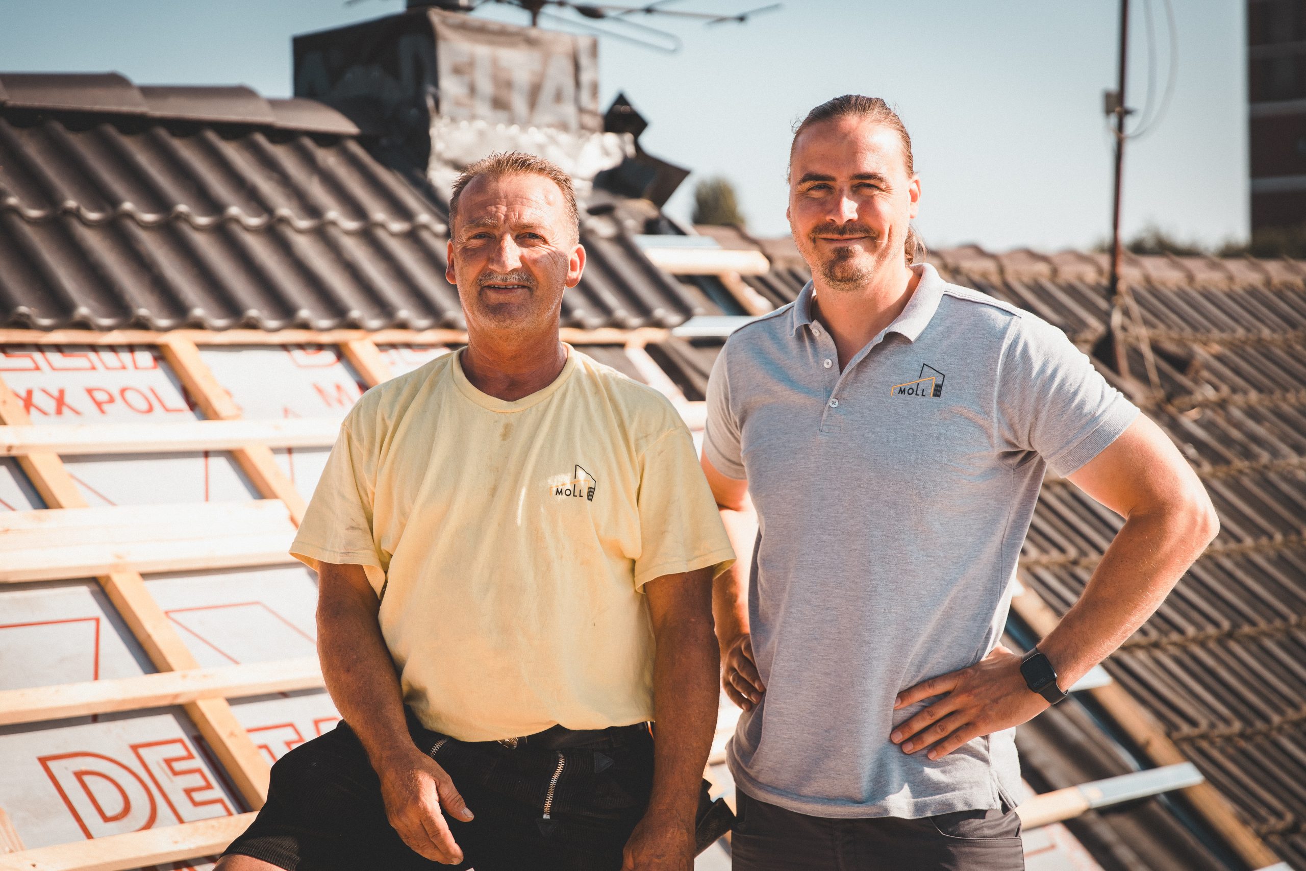 Vater und Sohn vom M-Team auf einem fertigen Dach